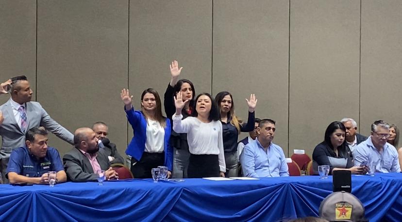 Representantes del Partido VAMOS El Salvador levantan mano derecha durante pacto de entendimiento entre partidos políticos por el TSE.